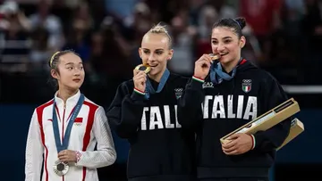 Reaksi pesenam China, Zhou Yaqin saat melihat dua rival Italianya menggigit medali usai sesi penyerahan medali cabor senam Olimpiade Paris 2024, Senin 5 Agustus (Gilliar - GES Sportfoto via Olympics.com) 