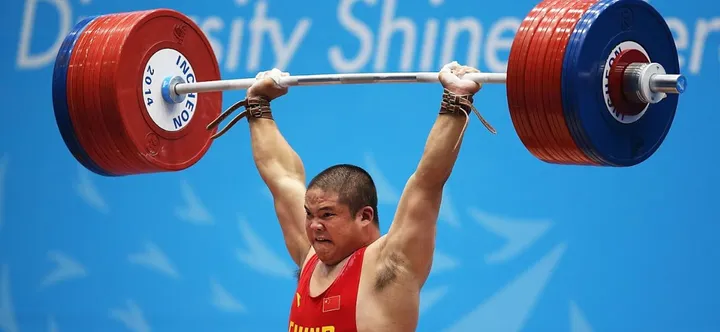 Seorang lifter angkat besi (Olympics.com).