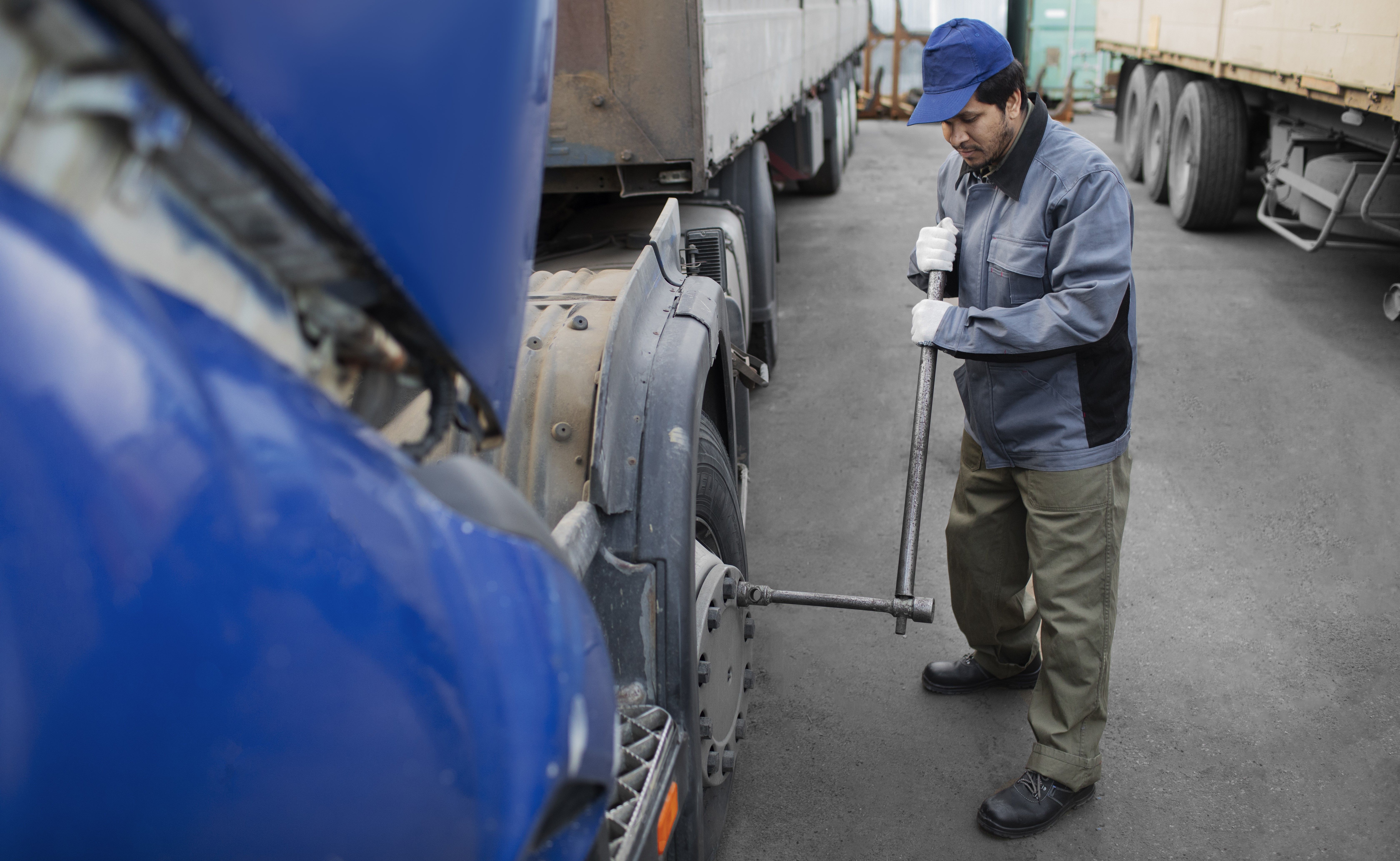 mechanic-checking-truck-full-shot - FREEPIK